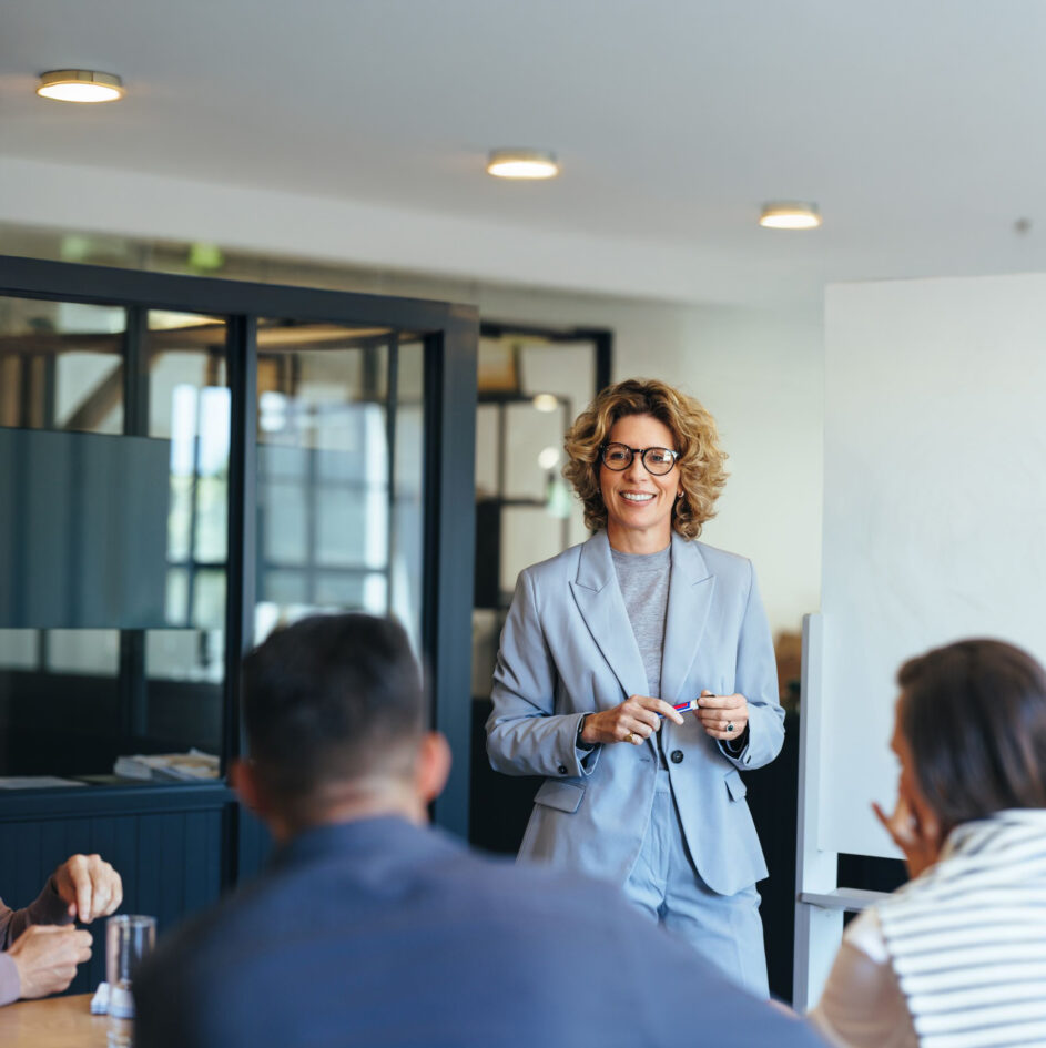 Mature business woman having a discussion with her team. Woman leading a meeting in an office