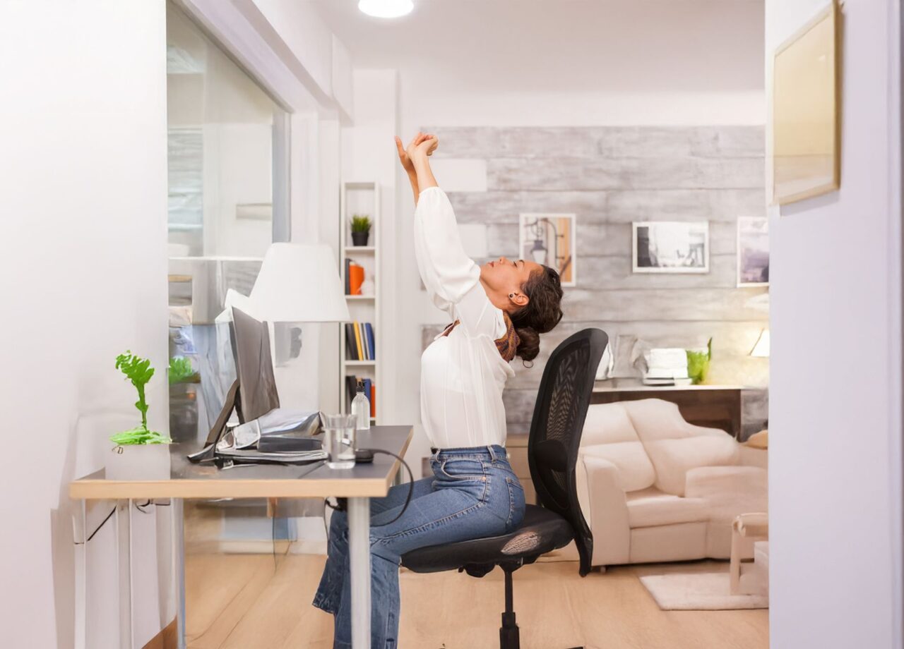 fatigued-woman-stretching-her-back-while-working-laptop-from-home-office-ai-erweitert
